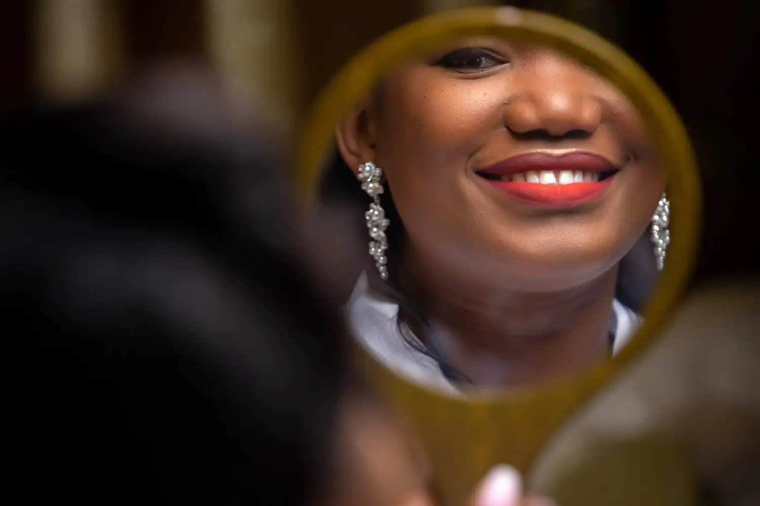 A wedding guest holding a mirror while the bride smiles